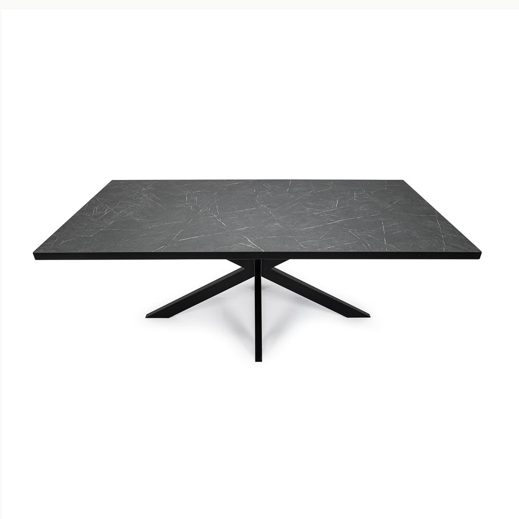 Rechthoekige zwarte tafel met marmeren effect en metalen kruisvormige poten, minimalistisch ontwerp.